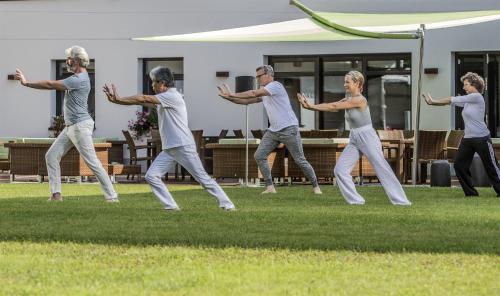 a group of people dancing in the grass at Johannesbad Hotel Königshof in Bad Füssing