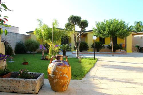 奧特朗托的住宿－La Pineta Residence，坐在院子一边的大橘色花瓶