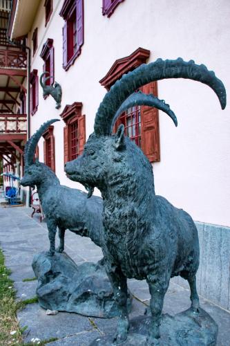 a statue of two goats standing next to a building at Hotel La Villa della Regina in Gressoney-la-Trinité