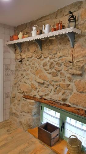 a stone wall with a shelf on a wall at Casa Rural Rojo del Tietar in La Iglesuela