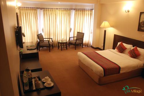 a hotel room with a bed and a table and chairs at Park Village Resort by KGH Group in Kathmandu