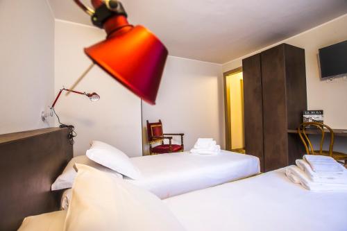 a hotel room with two beds and a red lamp at Locanda Mimmo in Bergamo