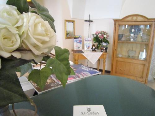 a table with a bouquet of white roses on it at Albergo Accademia in Trento