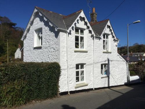 a white house with white windows on a street at Rosevean Cottage St Agnes in St. Agnes