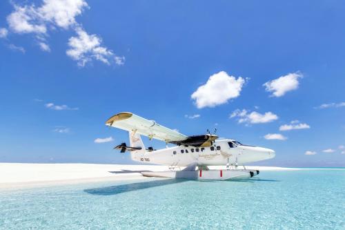a plane sitting in the water on a beach at Kudadoo Maldives Private Island – Luxury All inclusive in Lhaviyani Atoll
