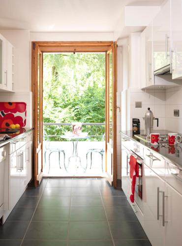 une cuisine avec une grande porte menant à un balcon dans l'établissement Aran Apartment - Chamonix, à Chamonix-Mont-Blanc
