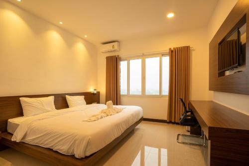 a bedroom with a bed and a large window at Intouch Riverside Hotel in Pakse