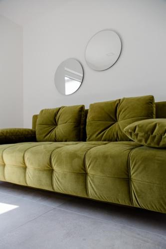 a green couch in a living room with a mirror at Einzigartiges Loft von Loftalive in Lollar