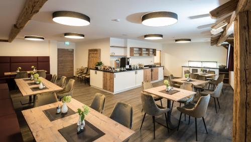 ein Restaurant mit Holztischen und -stühlen und einer Küche in der Unterkunft Landhotel Zum Adler in Oberbechingen