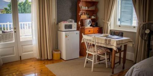 a small kitchen with a table and a microwave at Westbury House Guest House in Cape Town