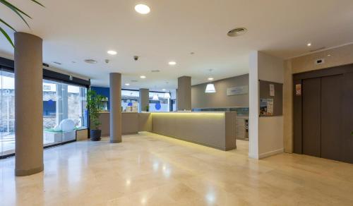 an office lobby with a reception desk and columns at Hotel Mar de Tossa in Tossa de Mar