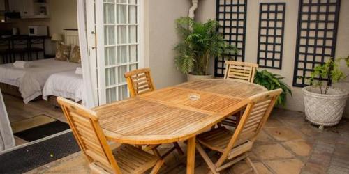 a wooden table and chairs in a room at Westbury House Guest House in Cape Town