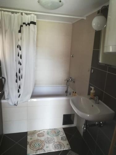 a bathroom with a sink and a shower curtain at Holiday home Pustodol in Donja Stubica