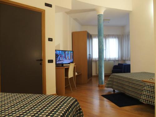 a hotel room with two beds and a television at Hotel Eden in Orbassano
