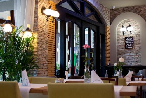 a dining room with tables and chairs and windows at Ambra Boutique Hotel & Bistro in Constanţa