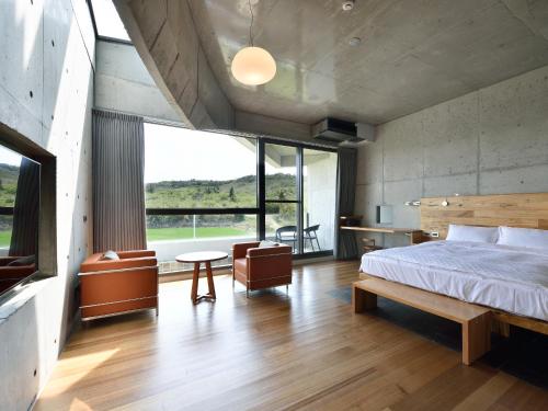 a bedroom with a bed and a large window at FaHaus in Checheng
