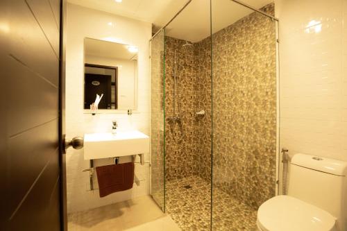 La salle de bains est pourvue d'une douche, de toilettes et d'un lavabo. dans l'établissement Intouch Riverside Hotel, à Pakse