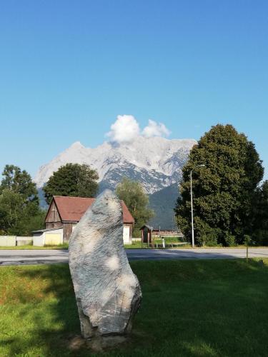 a statue of a bear in the grass with a mountain at Amtmannhaus Ferienunterkunft in Irdning