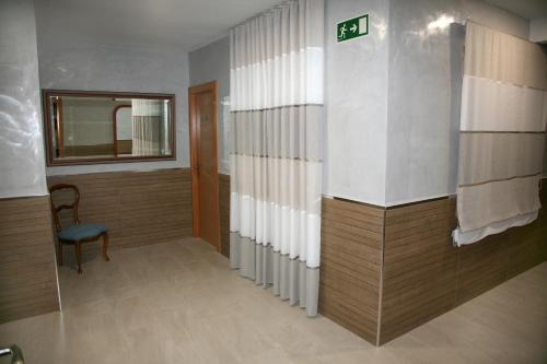 a hallway with a room with a chair and a window at Hostal Restaurante Grela in Pozo Alcón