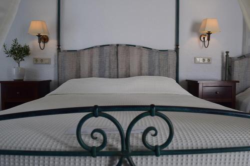 a bedroom with a large bed with a white bedspread at Aegialis Hotel & Spa in Aegiali