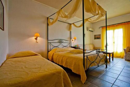 a bedroom with two beds with yellow sheets at Aegialis Hotel & Spa in Aegiali