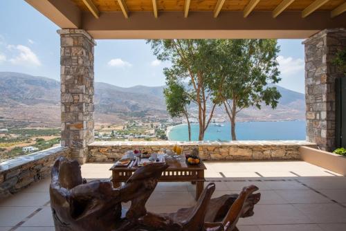 a table on a patio with a view of the water at Aegialis Hotel & Spa in Aegiali