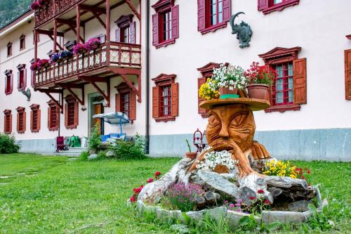 a statue in front of a building with flowers at Hotel La Villa della Regina in Gressoney-la-Trinit&eacute;