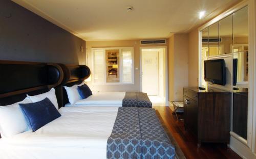 a hotel room with two beds and a television at Titanic City Taksim in Istanbul