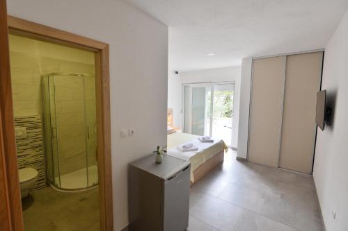 斯塔利格拉德－帕克萊尼采的住宿－Apartmani Smiljanic，一间卧室配有一张床,浴室设有淋浴。