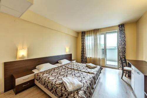a hotel room with a bed and a window at Hotel Arena in Samokov