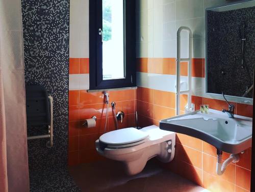 a bathroom with a toilet and a sink at Hotel '904 in Buggerru