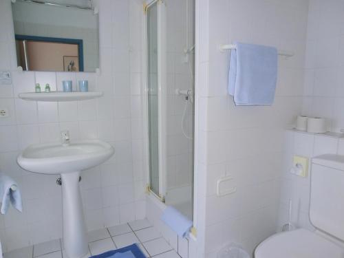 a bathroom with a sink and a toilet and a shower at Hotel Villa Strandrose in Ahlbeck