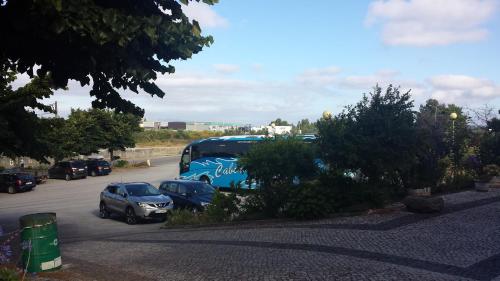 a blue bus parked in a parking lot with cars at Hospedaria D. Fernando in Viseu
