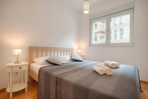 een slaapkamer met een bed met twee handdoeken erop bij Aria Apartments in Kotor