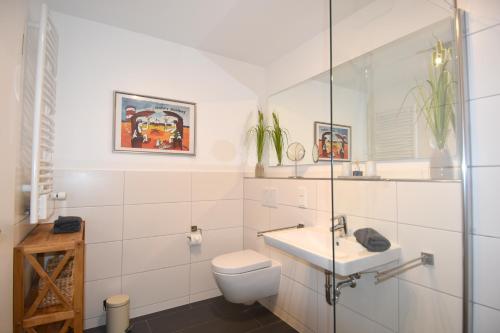 ハイリゲンハーフェンにあるOstseeperle inkl Strandkorb von Mai bis September und Wäsche Setの白いバスルーム(トイレ、シンク付)