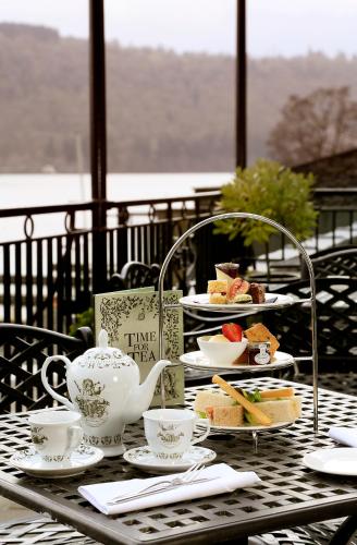 a table with plates of food and a tea kettle at Macdonald Old England Hotel & Spa in Bowness-on-Windermere