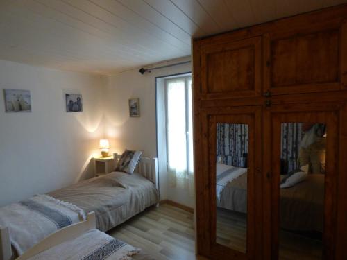 a bedroom with two beds and a dresser and a window at L'Ostalet in Prugnanes