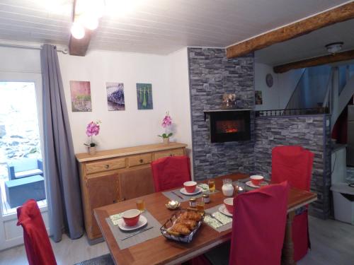 une salle à manger avec une table et une cheminée dans l'établissement L'Ostalet, à Prugnanes