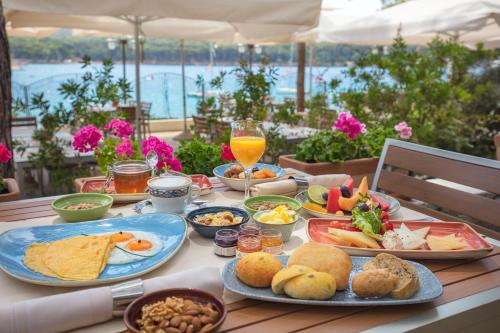 uma mesa com alimentos e bebidas para o pequeno almoço em Diana B&B em Mali Lošinj