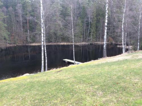 une masse d'eau avec un quai et des arbres dans l'établissement Berghaga 415, à Ullared