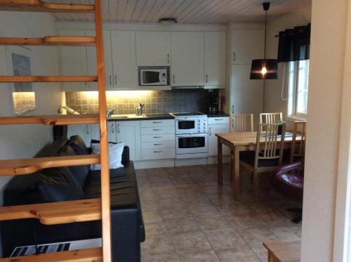 uma cozinha com uma cama alta e uma sala de jantar em Berghaga 415 em Ullared