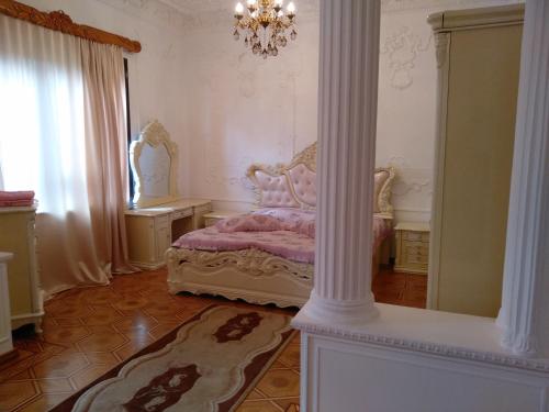 a bedroom with a bed and a large column at Hotel Royal in Kutaisi