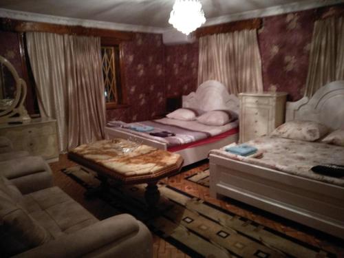 a bedroom with two beds and a couch and chairs at Hotel Royal in Kutaisi