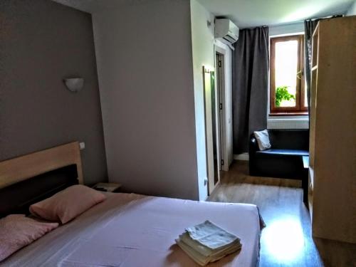 a bedroom with a bed and a chair and a window at Central Guesthouse in Bucharest