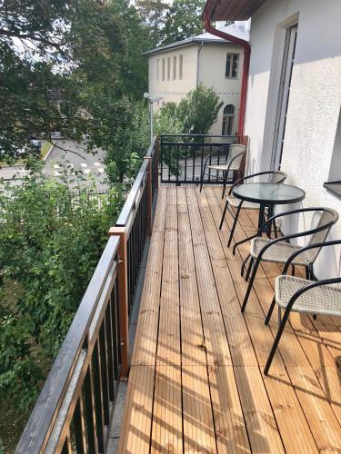 a wooden deck with tables and chairs on a balcony at Ontic Wellness Apartments in Tartu