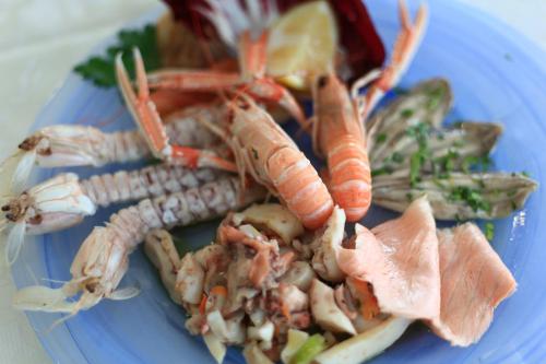 a blue plate of food with shrimp and vegetables at Hotel Giannino in Porto Recanati