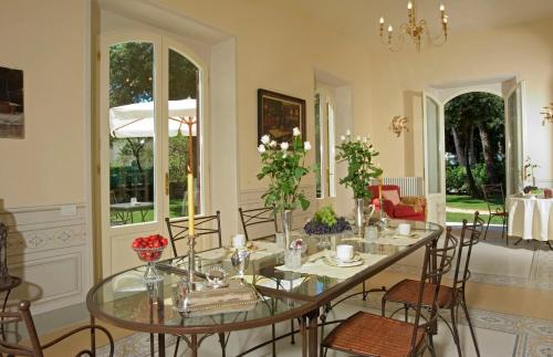 a dining room with a glass table and chairs at Villa Signori in Marina di Pietrasanta