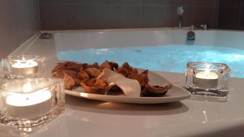 a plate of food next to candles and a bath tub at Park Boutique Hotel in Varaždin