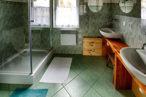 BiałowieżaにあるDomek Teremiskiのバスルーム(シャワー、バスタブ、シンク付)