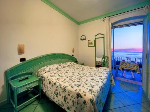 a bedroom with a bed and a view of the ocean at Hotel Casa del Sole in Ischia